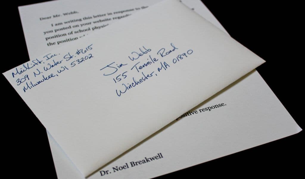 A white envelope with handwritten address, on top of a typed letter. A white envelope with handwritten address, on top of a typed letter.