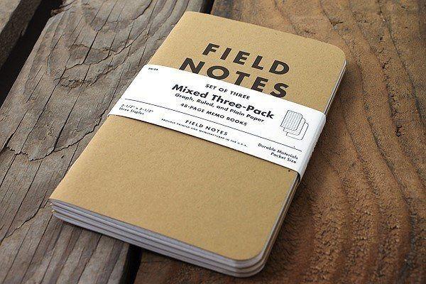A brown Field Notes notebook on a wooden board